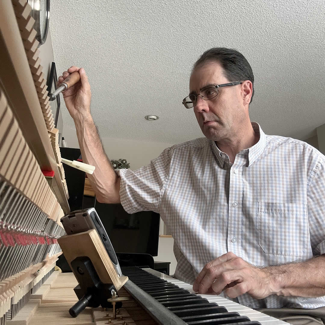 Photo of Mark tuning a piano